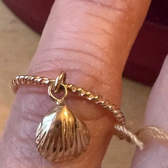 14 karat yellow gold cable ring with a beautiful shell hanging